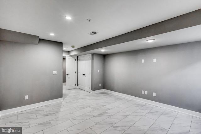 finished below grade area featuring marble finish floor, recessed lighting, visible vents, and baseboards