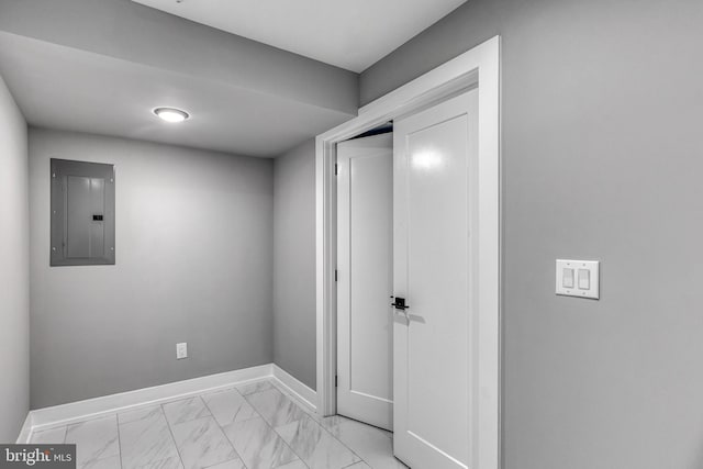 corridor featuring marble finish floor, electric panel, and baseboards