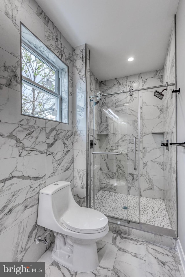 bathroom featuring stone wall, toilet, recessed lighting, marble finish floor, and a marble finish shower