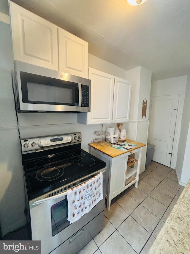 kitchen with open shelves, light tile patterned floors, appliances with stainless steel finishes, and white cabinets