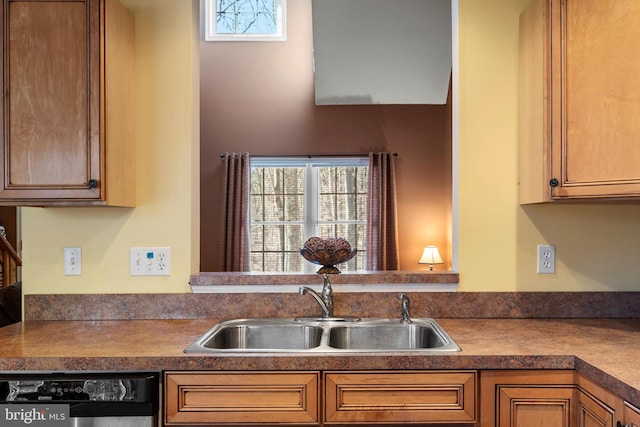 kitchen with black dishwasher, brown cabinets, a sink, and a healthy amount of sunlight