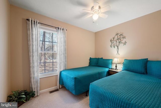 bedroom featuring light colored carpet, ceiling fan, visible vents, and baseboards