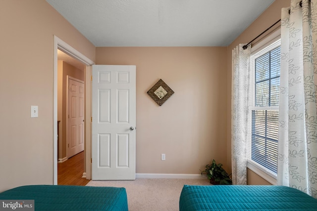 bedroom featuring baseboards and light colored carpet