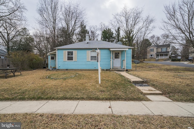 bungalow-style house with a front yard and a chimney