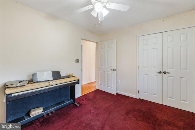 office area with carpet, a ceiling fan, and baseboards