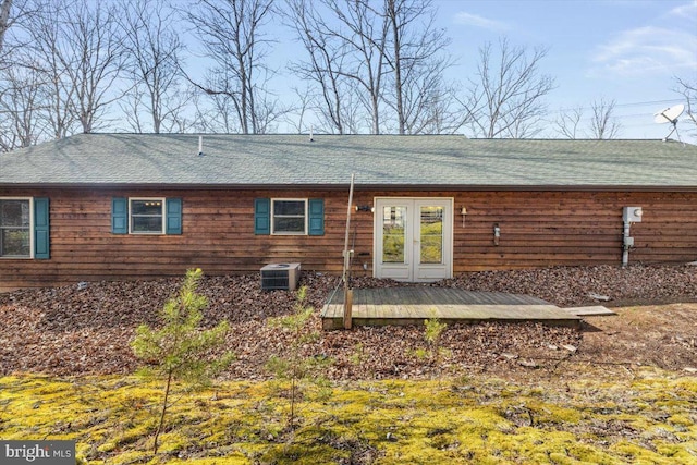 rear view of property with a deck, french doors, central AC unit, and a shingled roof