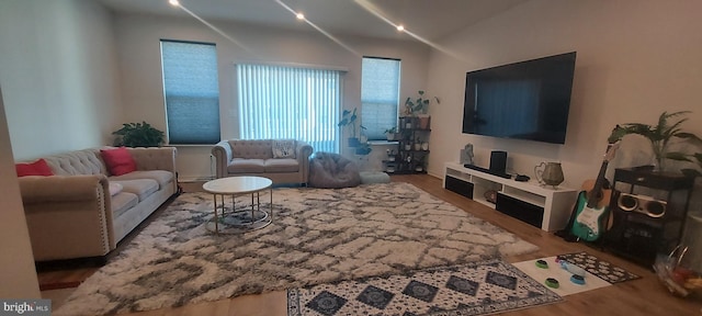 living area with vaulted ceiling and wood finished floors