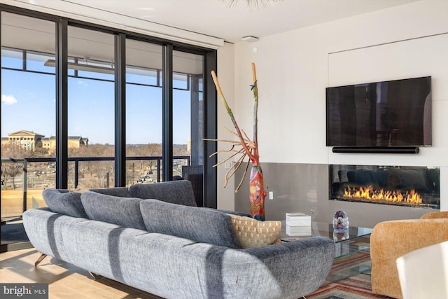 living area with a wall of windows and a glass covered fireplace