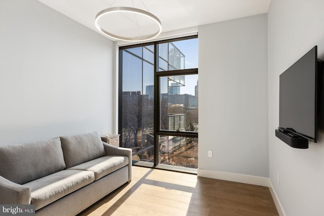 living room with baseboards, wood finished floors, and floor to ceiling windows