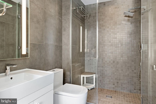 full bath featuring toilet, a stall shower, and vanity