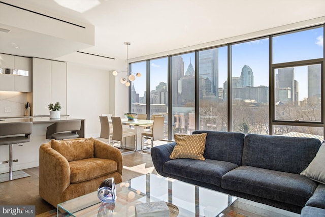 living area featuring a healthy amount of sunlight, light wood-style floors, a view of city, and floor to ceiling windows