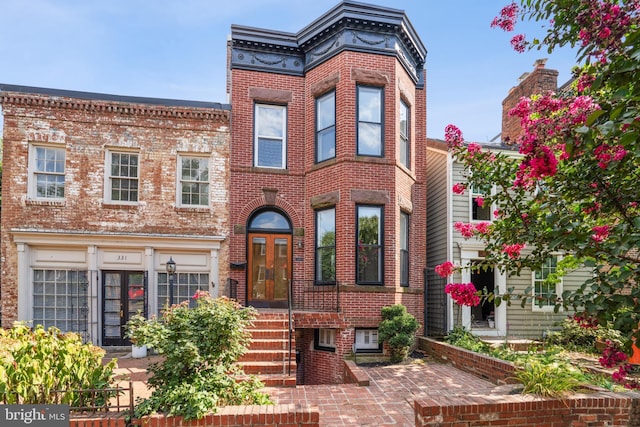 view of front of house featuring brick siding and french doors