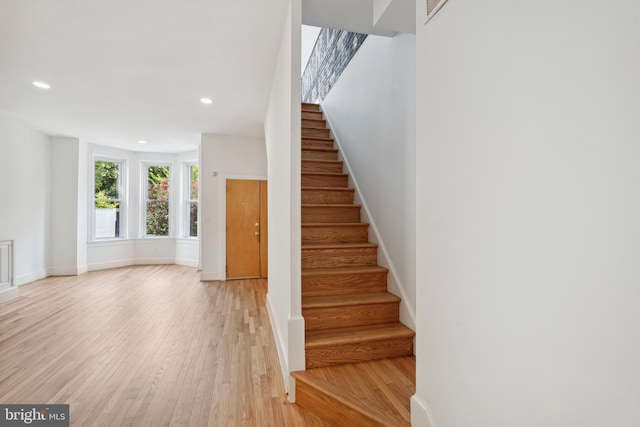 stairway featuring recessed lighting, baseboards, and wood finished floors