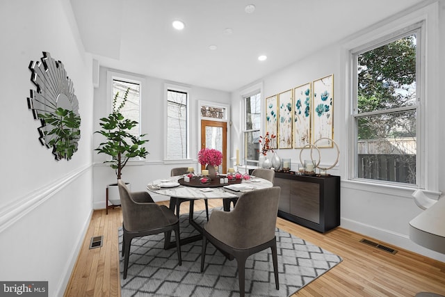 dining room featuring visible vents, plenty of natural light, and light wood-style flooring