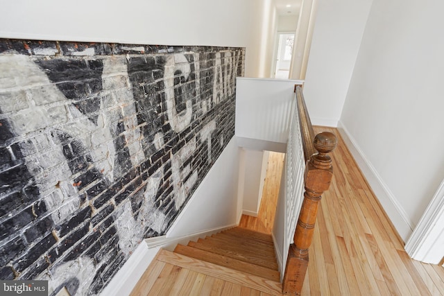 stairs with wood finished floors and baseboards