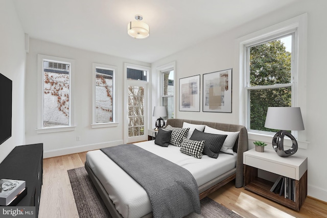 bedroom with light wood-type flooring and baseboards