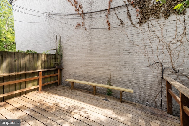 wooden terrace featuring fence