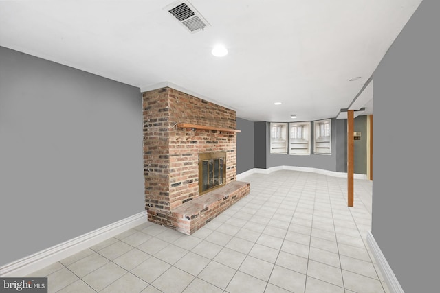 unfurnished living room featuring a brick fireplace, light tile patterned floors, baseboards, and visible vents