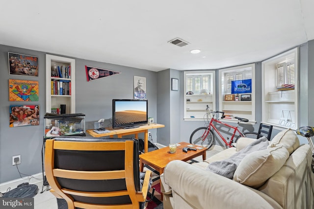 office area with visible vents, baseboards, and built in features