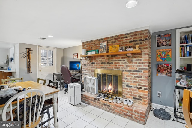 dining room featuring light tile patterned floors, a fireplace, and visible vents