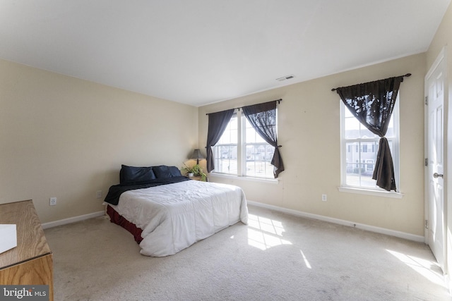 carpeted bedroom featuring visible vents and baseboards