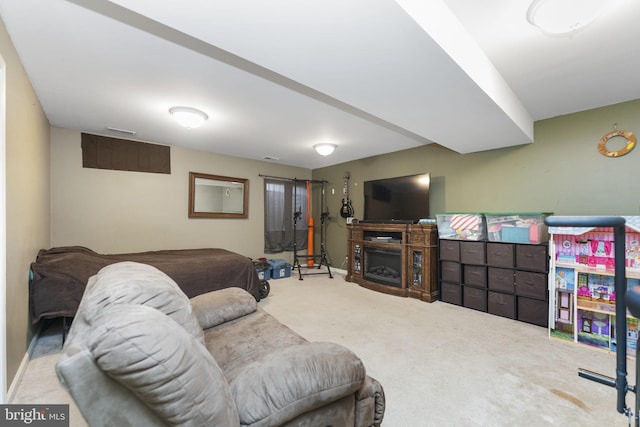 carpeted living area featuring baseboards, a fireplace, and visible vents