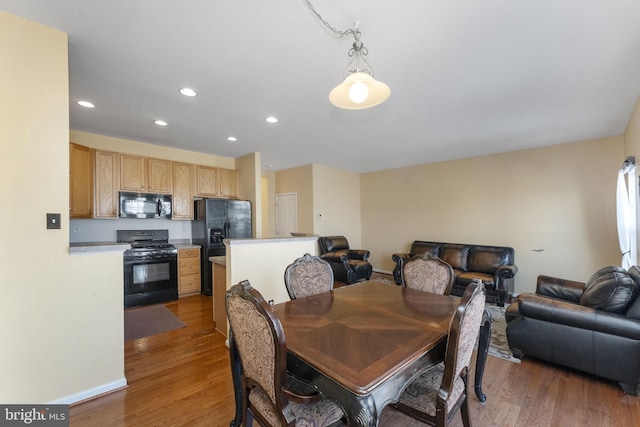 dining area with wood finished floors and recessed lighting