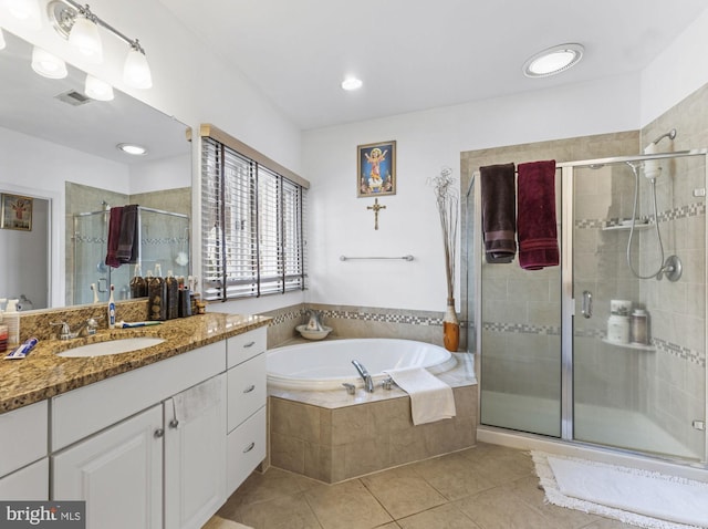 bathroom featuring a stall shower, tile patterned flooring, a garden tub, and vanity