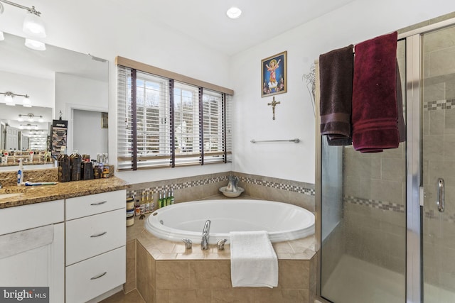 full bathroom with a garden tub, vanity, and a stall shower