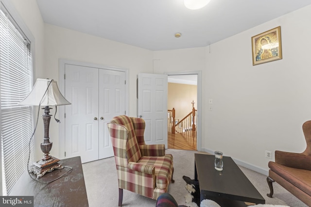 living area with light carpet and baseboards