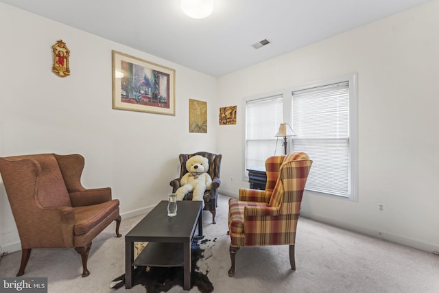 sitting room with carpet floors, baseboards, and visible vents