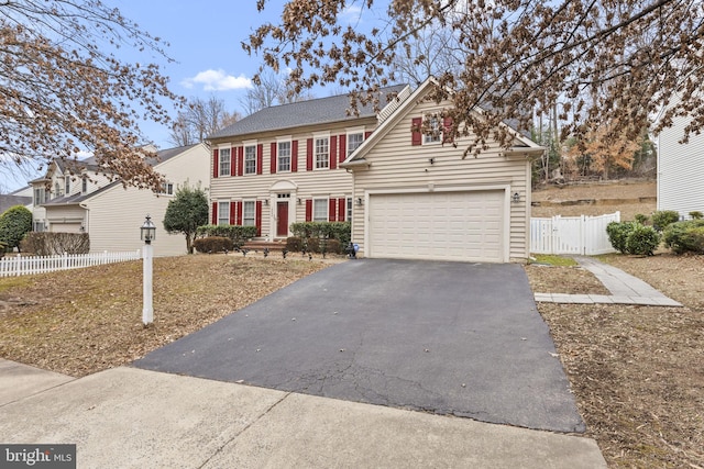 view of front of home featuring a garage, driveway, fence, and a gate