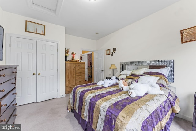 carpeted bedroom featuring attic access and a closet