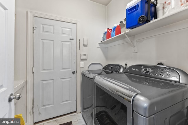 washroom featuring laundry area, marble finish floor, and washer and clothes dryer