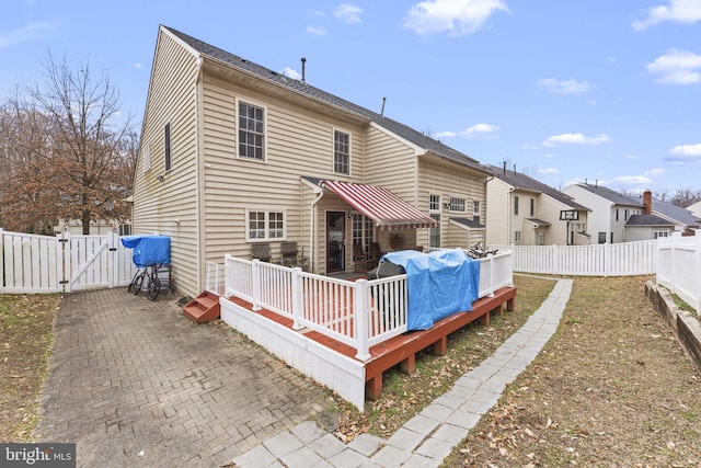 rear view of house featuring a patio area, a gate, a fenced backyard, and a wooden deck