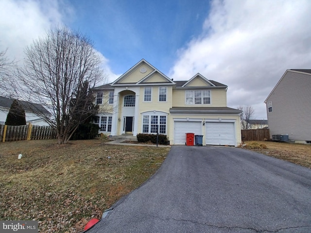 view of front of property with fence, driveway, an attached garage, and central AC unit