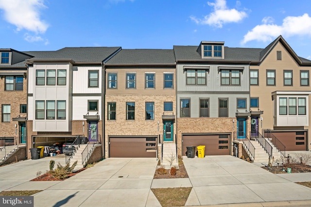 townhome / multi-family property with a garage, concrete driveway, and brick siding