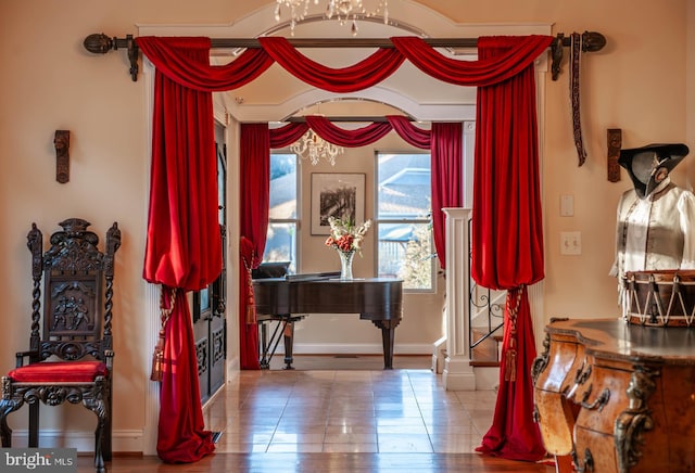 living area featuring a chandelier and baseboards