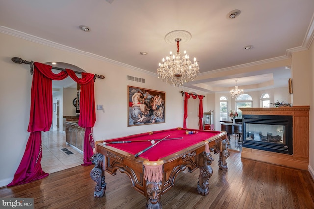 playroom featuring crown molding, a notable chandelier, visible vents, wood finished floors, and a multi sided fireplace