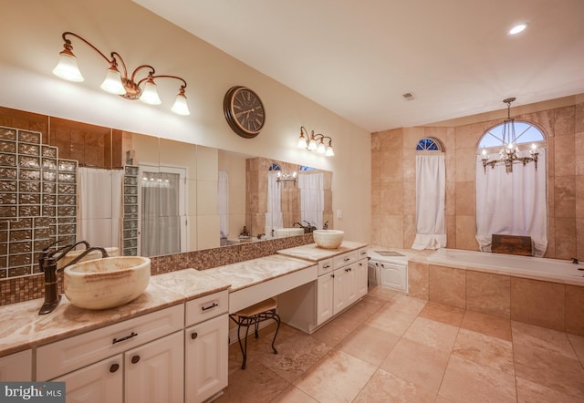 full bath featuring a notable chandelier, tiled bath, tiled shower, and vanity