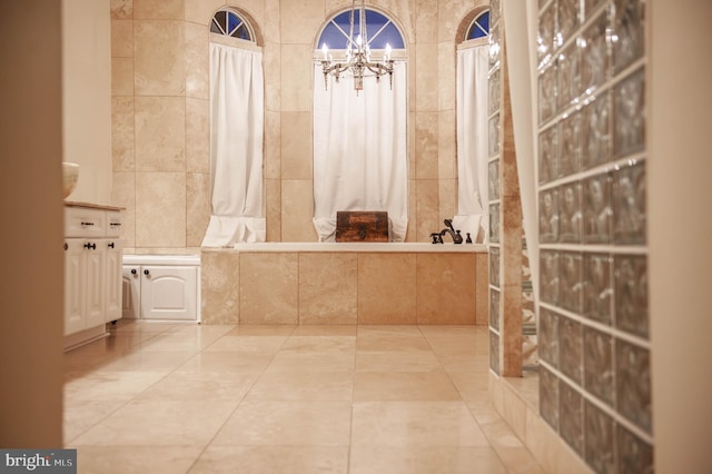 full bathroom featuring a notable chandelier, tile walls, tile patterned floors, a tile shower, and a bath