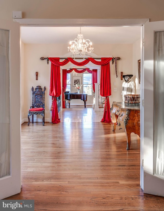 interior space featuring a chandelier, baseboards, and wood finished floors