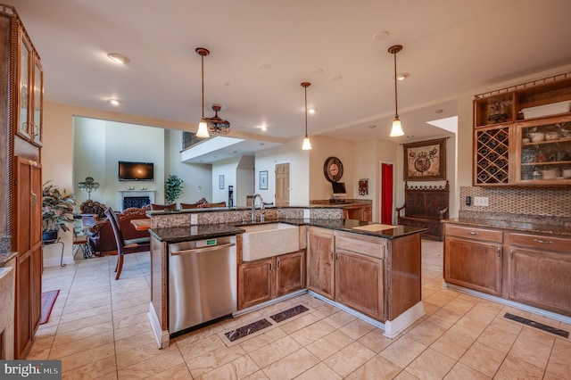 kitchen featuring visible vents, dishwasher, open floor plan, a fireplace, and a sink