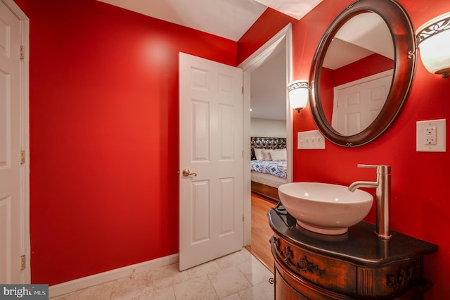 bathroom featuring tile patterned flooring, baseboards, and vanity