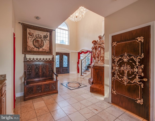 foyer entrance with baseboards, a towering ceiling, stairway, marble finish floor, and french doors