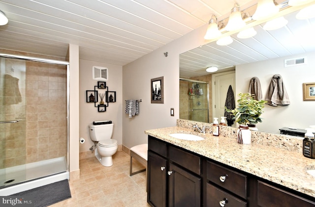 bathroom with visible vents, toilet, a shower stall, vanity, and baseboards