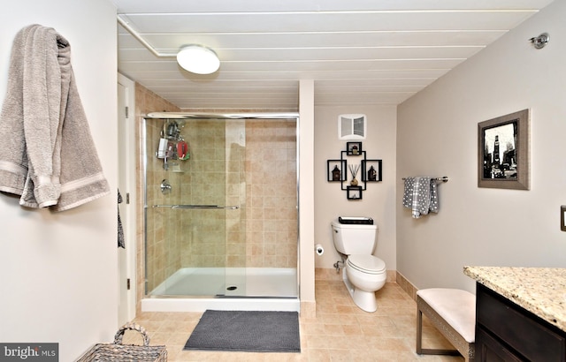 full bath featuring toilet, a shower stall, vanity, tile patterned flooring, and baseboards