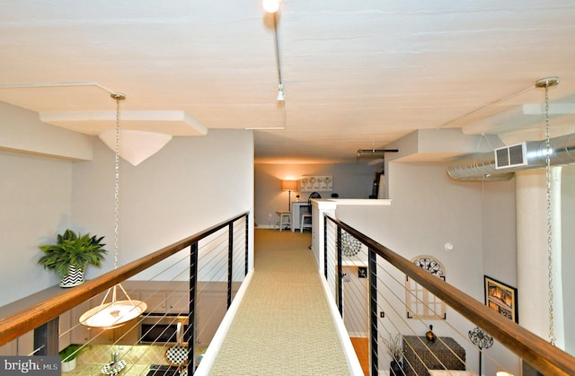 hall featuring carpet flooring, visible vents, and an upstairs landing