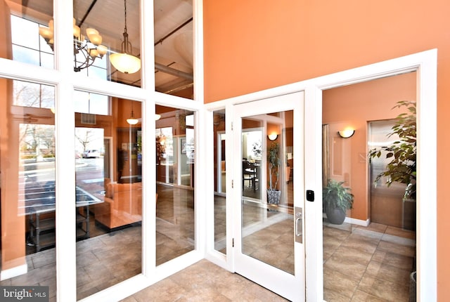 interior space with a chandelier, french doors, and a high ceiling