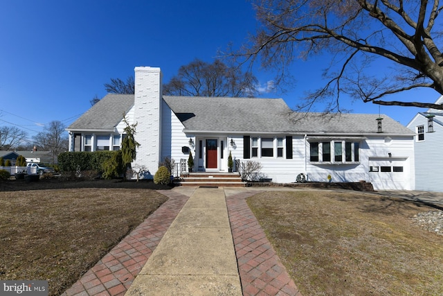 view of front facade featuring a garage, a shingled roof, and a chimney